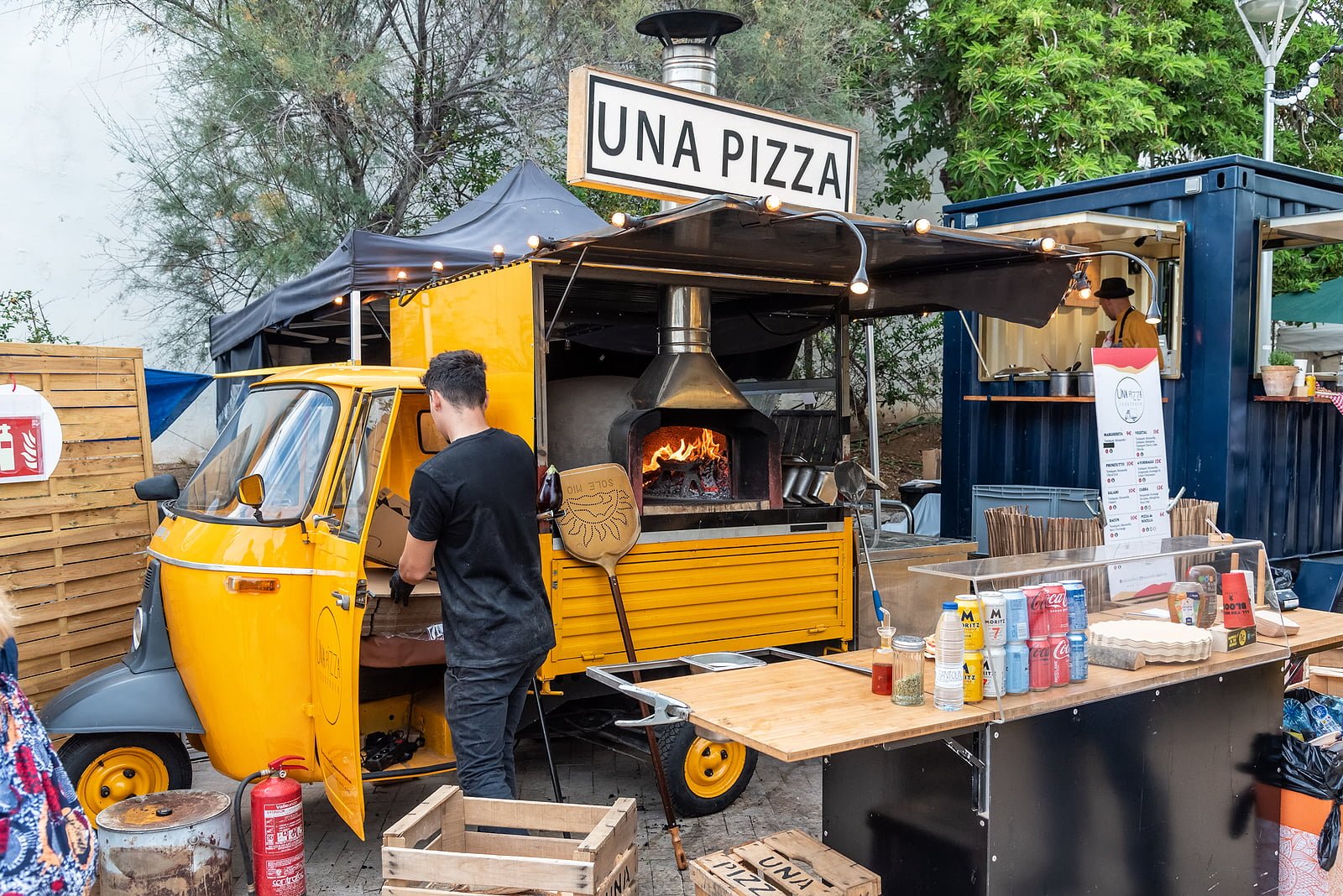 SITGES, BARCELONA, SPAIN - OCTOBER 08, 2022: light commercial vehicle with three wheels enabled for the preparation of fast food with a wood-fired oven to make pizzas